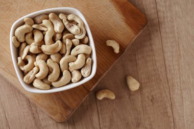 Tahta kesme tahtasının üzerinde, mermer masanın üstünde, tabakta fındıklı fındıklar. Metin için boşluk