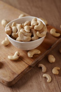 Tahta bir sehpanın üzerinde, tabakta fındıklı fındıklar, yan görüş. Metin için boşluk