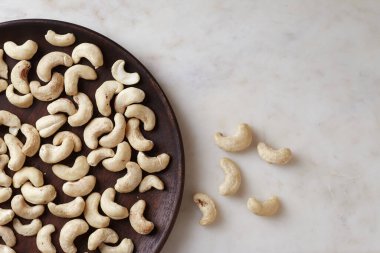 Ahşap bir tabakta, mermer masanın üstünde, nefis fındıklar, üst manzara. Metin için boşluk