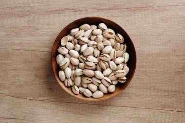 Ahşap bir masada, bir kasede fıstıklı fındık, harika bir manzara. Metin için boşluk