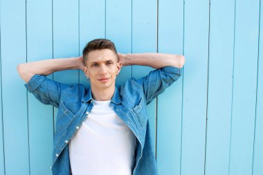 Cyan duvarının arkasında genç yakışıklı bir adam var..