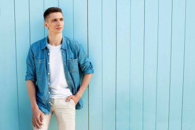 Cyan duvarının arkasında genç yakışıklı bir adam var..