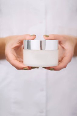 Profesyonel kadın güzellik doktorunun elinde bir ürünün yakın çekimi..