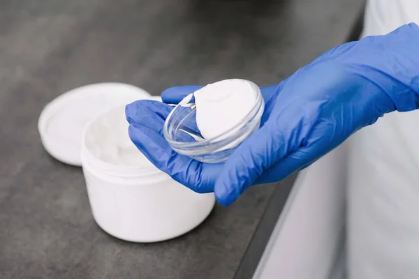 Profesyonel kadın güzellik doktorunun elinde bir ürünün yakın çekimi..