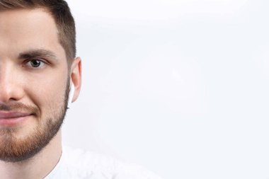 Beyaz gömlekli bir adam telsiz kulaklık takıyor. İzole et