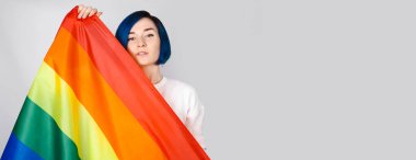 Igbtq konsepti. Stüdyoda mavi saçlı, gökkuşağı bayrağı taşıyan pozitif kadınlar izole edilmiş.