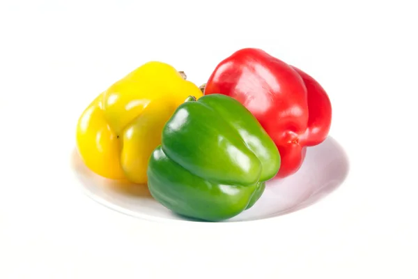 Red, green and yellow peppers on the plate — Stock Photo, Image
