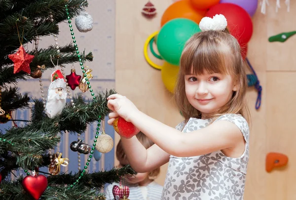 Tyttö koristaa uudenvuoden puun — kuvapankkivalokuva