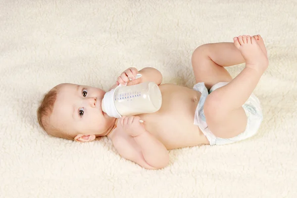 Bebé con una botella de leche Imagen de archivo