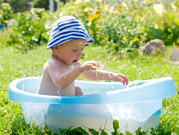 Piccolo bambino (1 anno) giochi nella vasca da bagno nella natura Fotografia Stock
