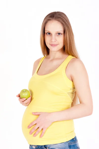 Smiling pregnant in a yellow t-shirt with green apple — Stock Photo, Image