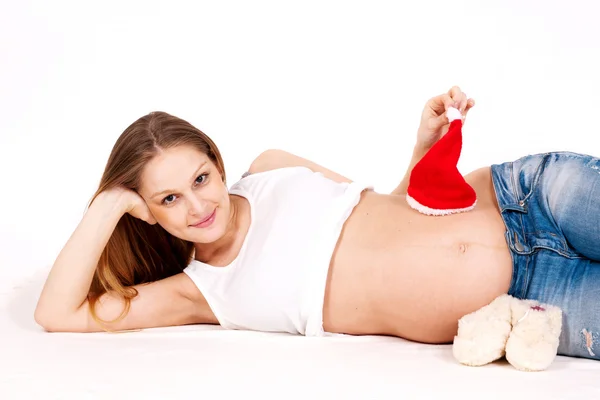 Happy pregnant with a red cap and booties on a white background — Stock Photo, Image