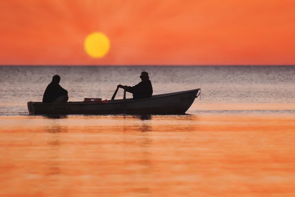 Due sagome di uomini in una barca da pesca — Foto Stock