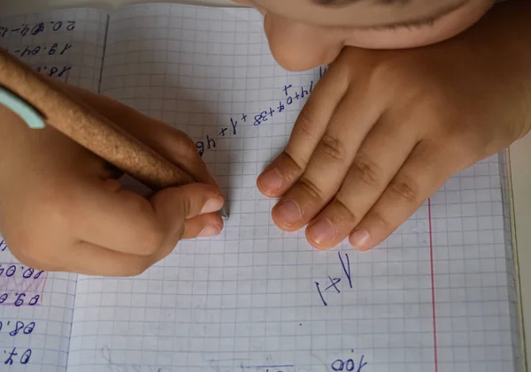 Çocuk not defterine numara yazmayı öğreniyor.