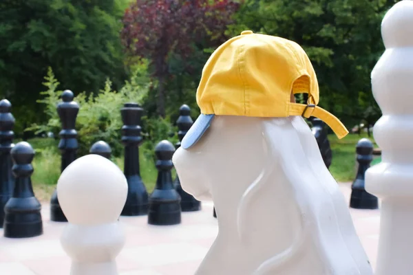 Dev bir satranç atının üzerinde sarı ve mavi bir şapka.