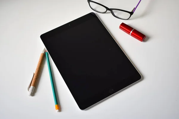 Çalışma tableti masada, kalem, kalem ve gözlük.