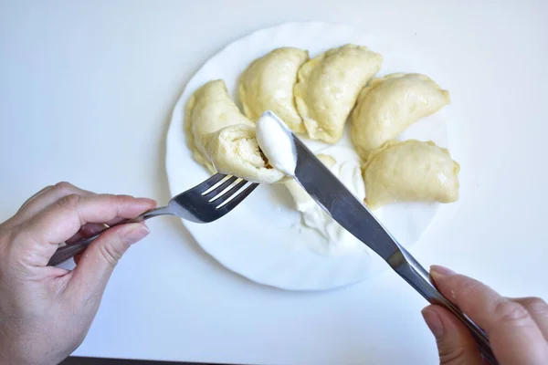 Bir insan peynirli hamur tatlısı yer.