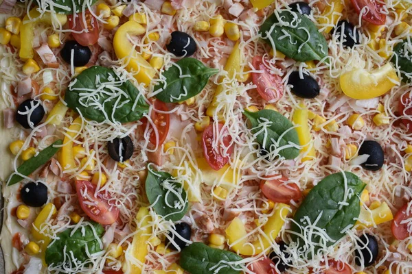 Pişirmeden önce rendelenmiş peynirli pizza