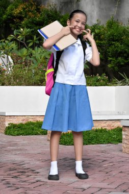 Kız öğrenci ayakta komik surat yapıyor.