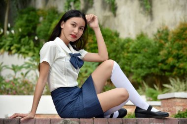 Oturan Etek Giyen Genç Öğrenci pozu