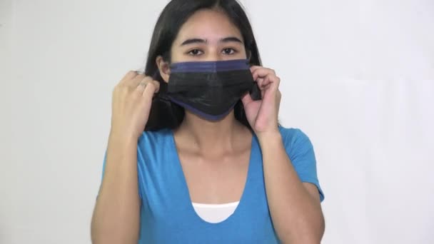 Egy ázsiai tinédzser nő visel maszkot — Stock videók