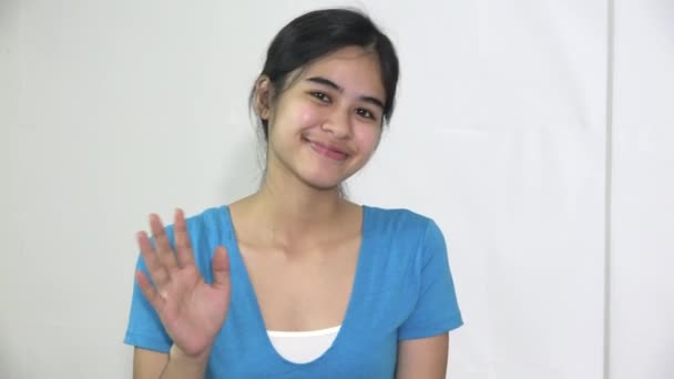 Een vrouwelijke aziatische tiener meisje zwaaien — Stockvideo