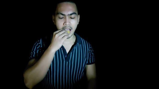 Un homme asiatique mangeant des chips de maïs — Video