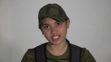 Sırt çantalı bir kadın asker konuşuyor.