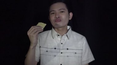 Bir Asyalı adam kraker yiyor.