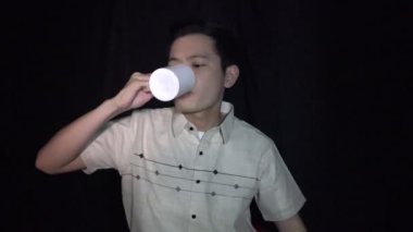 Kahve ya da çay içen Asyalı adam