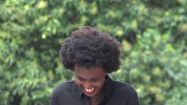 Afrikalı Kadın gülüyor ve ağzını kapatıyor.
