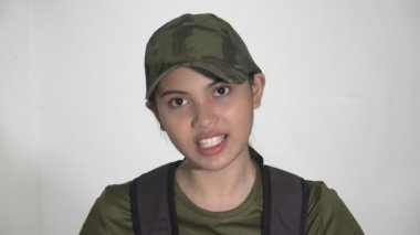 Sırt çantalı bir kadın asker konuşuyor.