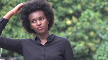 Saçına dokunan siyah bir kadın