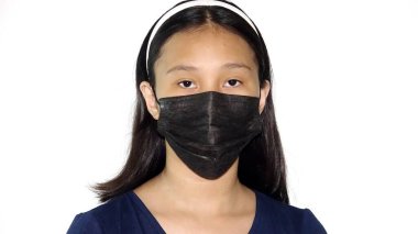 Yüz maskesi takan Asyalı bir kadın.