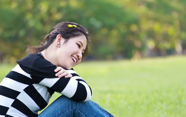 Aziatische vrouw ontspannen op het gras — Stockfoto