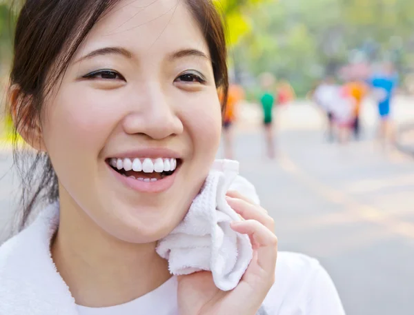 Asiatisk kvinna torka svett med en handduk efter träningen — Stockfoto