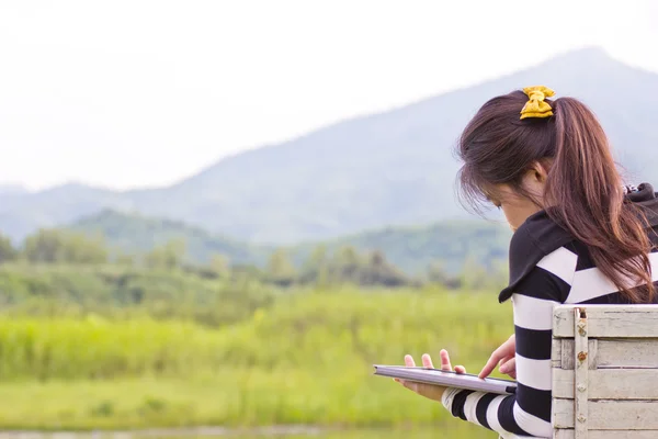 Jeune femme utilisant une tablette à vue sur la montagne — Photo