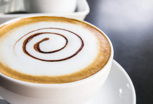 Kaffekopp och fat på svart bord — Stockfoto