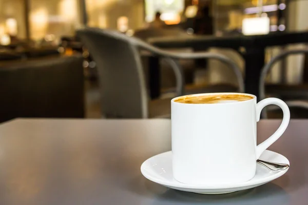 Taza de café y platillo en la mesa en la cafetería — Foto de Stock