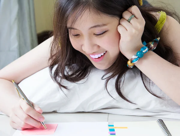 Mulher asiática escrevendo no bloco de notas — Fotografia de Stock