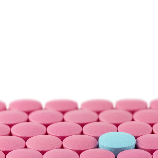 Blue pill between pink pills on white background — Stock Photo, Image