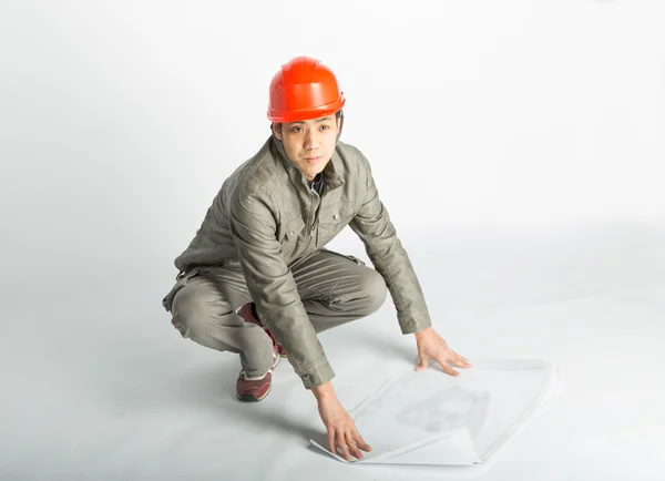 Trabajador de la construcción masculino y bocetos planos — Foto de Stock