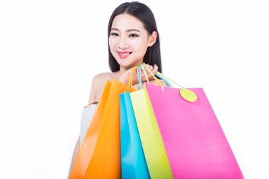 Beyaz arka planda alışveriş torbaları olan genç bir kadın.