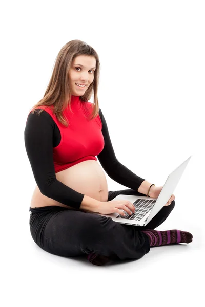 妊娠中の smilling 女性のラップトップ ロイヤリティフリーのストック画像