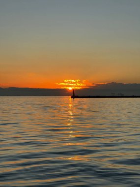 Denizde gün batımının sakin manzarası.