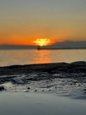 Denizde gün batımının sakin manzarası.