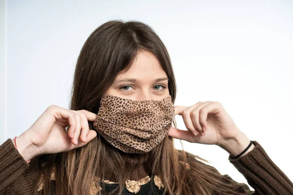 Woman having fun with a mask wearing brown mask, protecting herself from covid