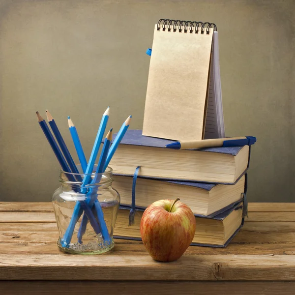 Vecchi libri con matite, mela e taccuino — Foto Stock