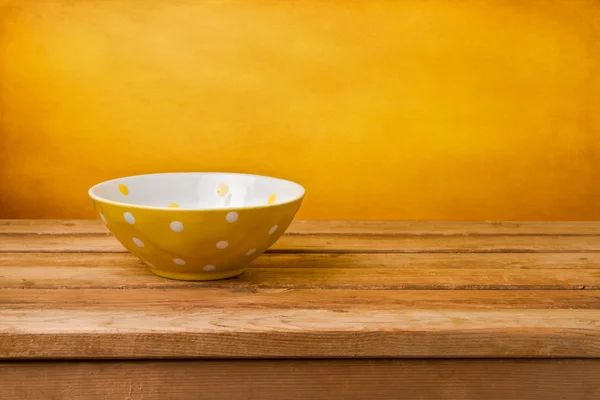 Cuenco amarillo vacío con puntos en la mesa de madera —  Fotos de Stock