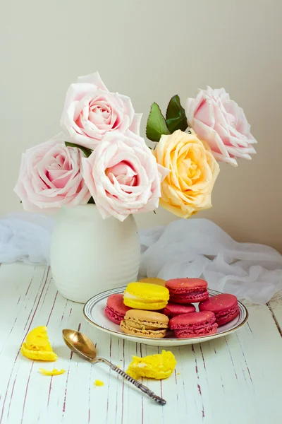 Still life with rose bouquet and macaroons — Stock Photo, Image